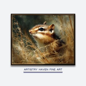 May include: A framed fine art print featuring a detailed portrait of a chipmunk. The chipmunk, with brown and white fur, is nestled among tall, dry grasses. The artwork has a soft, painterly style with a muted color palette. The text "ARTISTRY HAVEN FINE ART" is at the bottom.