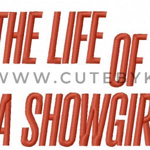 Könnte beinhalten: Gesticktes Design mit dem Text "THE LIFE OF A SHOWGIRL" in Rot, sowie ein rotes Vorhängeschloss mit einem türkisblauen Schlüsselloch. Die Website-Adresse www.cutebykira.com ist ebenfalls enthalten.