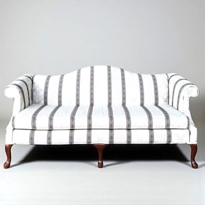 May include: A white sofa with vertical gray striped pattern and curved arms. The sofa has a wooden frame with four curved legs. The upholstery features a repeating pattern of gray stripes and floral accents.