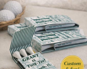 May include: Customized matchbook-style paper sleeves containing white golf tees. The green and white patterned packaging features the text GRANT IS THIR-Tee! Jacksonville, FL 4.1.26. A yellow circular badge with the text Custom & fun! is visible.