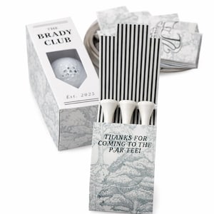 May include: Personalized golf tee holders for weddings and events. The image shows a white golf ball in a box with "THE BRADY CLUB" printed on it. The box is decorated with a gray and white pattern. The text "THANKS FOR COMING TO THE PAR-TEE!" is printed on the matchbook-style holder.