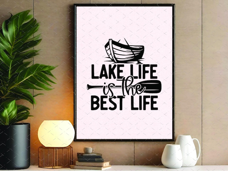 May include: Black framed wall art with the text "LAKE LIFE is the BEST LIFE" in a bold, modern font. The design includes a silhouette of a boat and an oar, perfect for lake house decor or a gift for lake lovers.