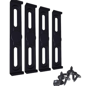 Puede incluir: Cuatro soportes de estante de plástico negro con cuatro tornillos negros. Los soportes tienen dos agujeros cada uno y un borde redondeado.