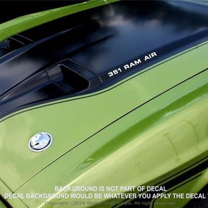 May include: A green car hood with a black ram air hood scoop and a white decal that reads "351 RAM AIR".