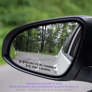 May include: A black rearview mirror with a white decal that reads "Objects in mirror are losing" in black text.