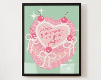 May include: A framed art print featuring a pink heart-shaped cake design with cherries and bows. The cake has the text "Write your name on your paper" in a cursive font. The background is a light green color with white star accents.