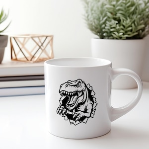 May include: White ceramic mug featuring a black and white illustration of a dinosaur head breaking through the surface. The dinosaur is facing the right side of the mug.