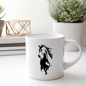 May include: White ceramic mug featuring a black silhouette of a horse. The horse design is on the front of the mug. The mug has a curved handle and is sitting on a white surface.