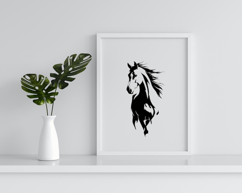 May include: A framed black and white horse art print. The artwork features a stylized illustration of a horse's head and flowing mane. The print is displayed on a white shelf next to a white vase with green leaves.