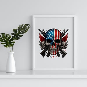 May include: A framed print featuring a skull design with the American flag painted on it. The skull has red wings and is crossed with two rifles. The print is in a white frame and is displayed on a white shelf.