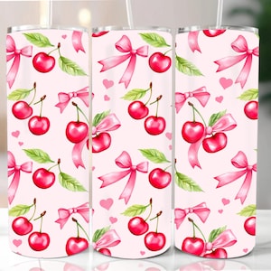 May include: Three pink and white stainless steel tumblers with a repeating pattern of pink bows and red cherries.