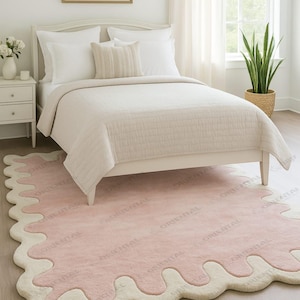 Hand tufted wool rug 5x7 ft soft pastel pink for cozy room Cute pastel pink rug 4x6 ft with scalloped cream border.