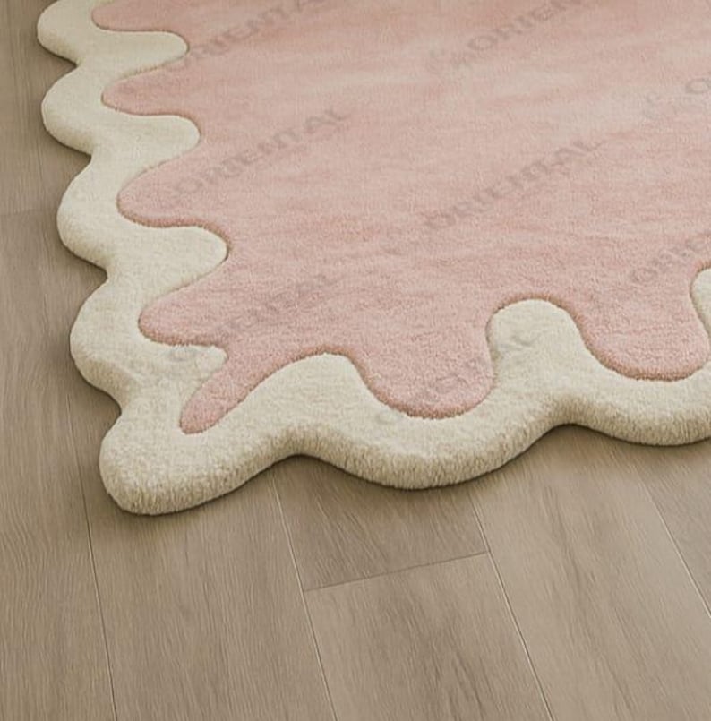 Handmade scallop rug 6x9 ft in light-filled cozy bedroom Hand tufted pink wavy edge rug 5x7 ft styled in cozy white bedroom.