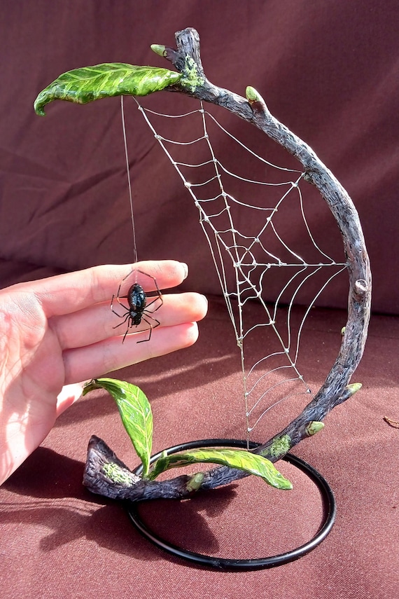 A jaw-dropping hand-crafted silver wire spider web with a magnetically hanging spider — 91 favorites don't lie, this is gothic desk art at its finest.