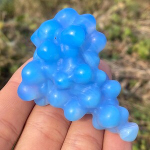 May include: A cluster of blue and white agate beads, resembling a bunch of grapes, with a smooth, polished surface.