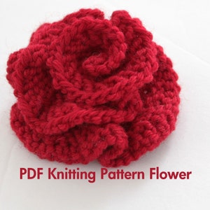 May include: A red crocheted flower, a knitting pattern for which is available as a PDF download.