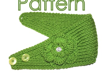 May include: A green knitted headband with a flower detail and two buttons. The flower has a rhinestone in the centre.