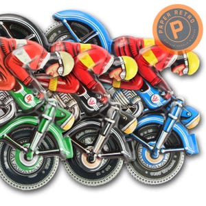 May include: A vintage-style metal wall art piece featuring a row of racing motorcycles. Each motorcycle is painted in a different color, with riders in red, yellow, and white helmets. The piece has a retro aesthetic.