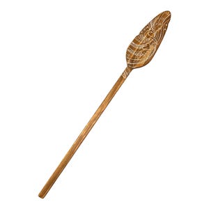 Op de afbeelding: Een houten peddel met een gesneden ontwerp. De peddel is bruin en heeft een wit ontwerp.