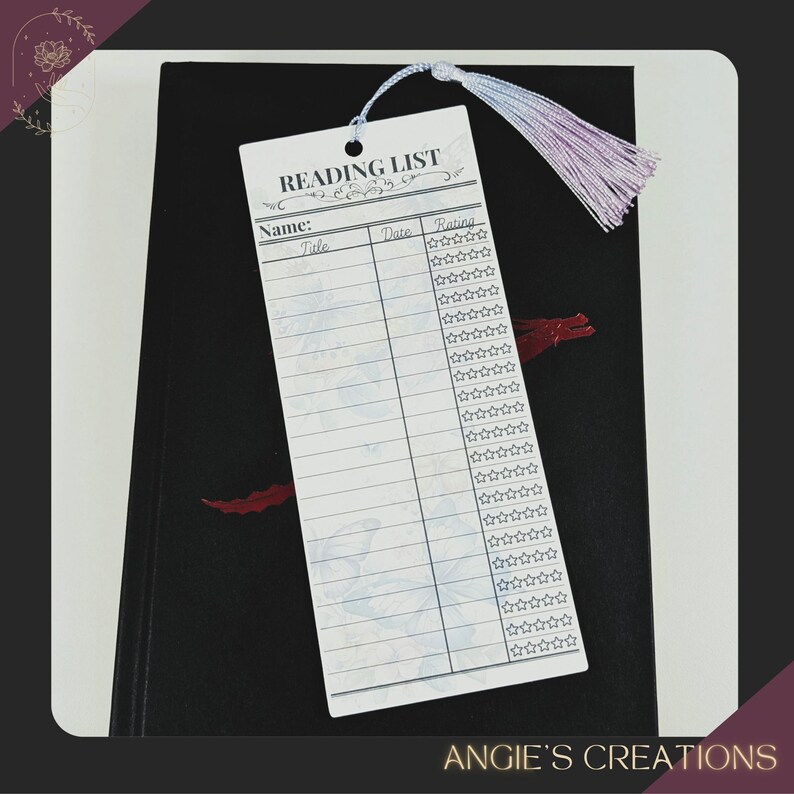a reading list card with a tassel attached, placed on top of a black notebook or binder.