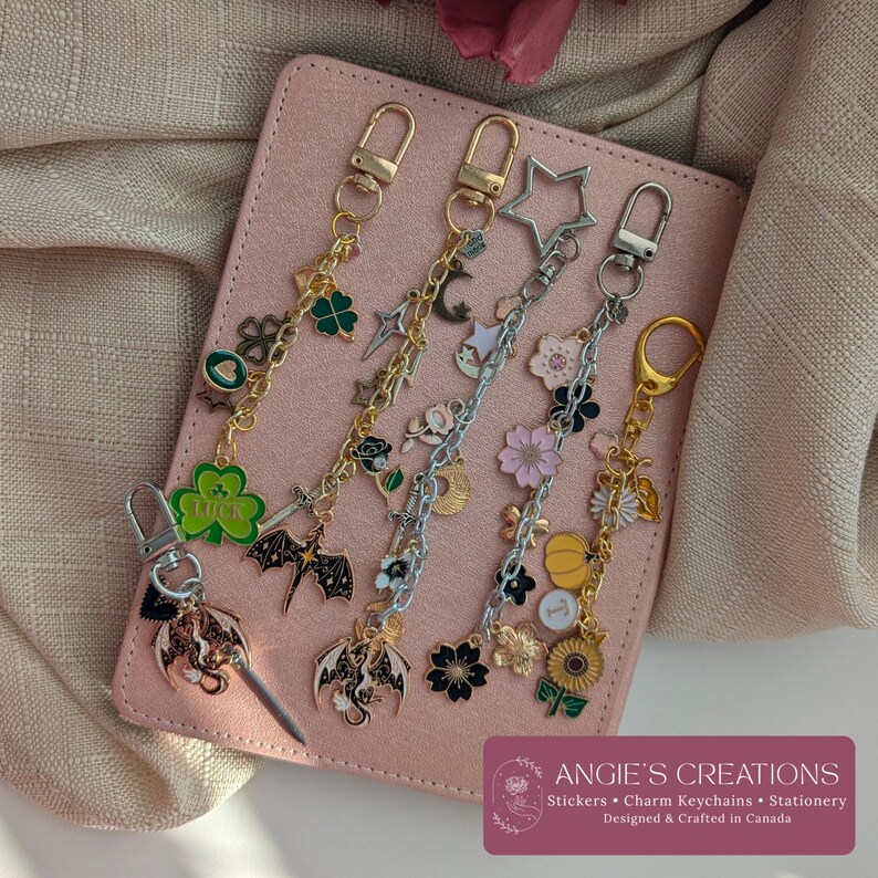 Pu&ograve; includere: Cinque portachiavi con ciondoli in metallo con vari design, tra cui un quadrifoglio verde con la parola LUCK, un drago nero, una stella argentata, fiori di ciliegio rosa, una zucca gialla e un girasole, fissati a moschettoni dorati e argentati.