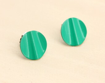 May include: A pair of round, green earrings with a ridged texture. The earrings are made of metal and have a shiny finish.