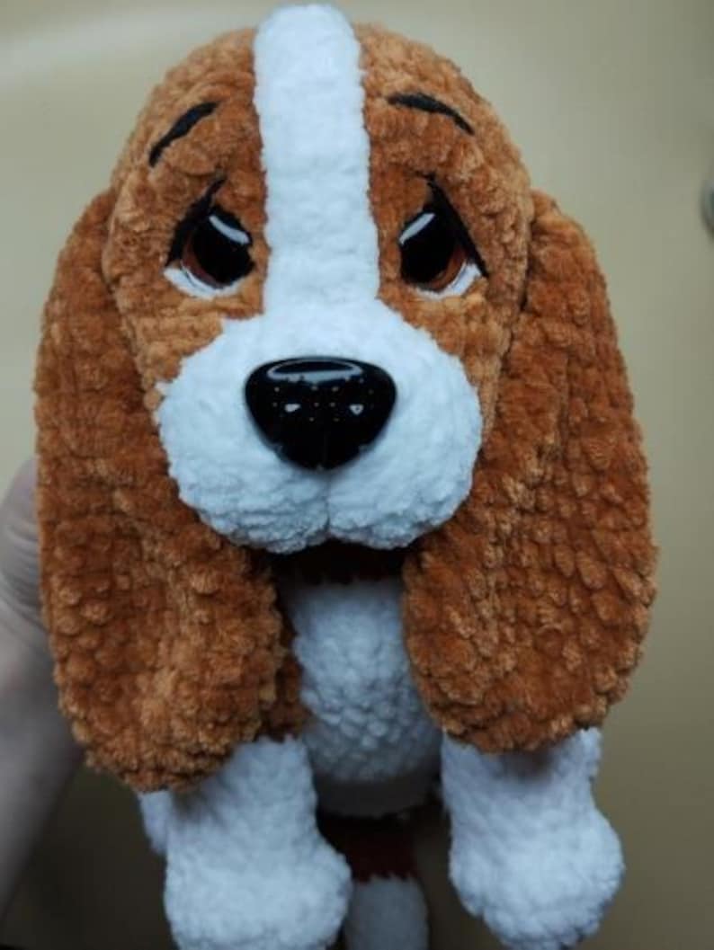 Peut inclure: Une peluche faite &agrave; la main repr&eacute;sentant un chien beagle. Le jouet est marron, blanc et noir, avec de grands yeux expressifs et des oreilles tombantes. Le chien a un nez noir et est fait d'une mati&egrave;re douce et textur&eacute;e.