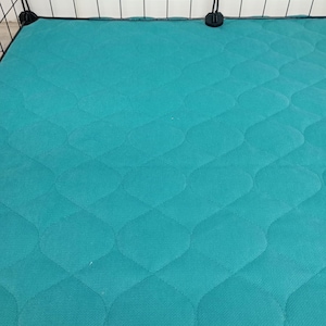 May include: Teal quilted cage liner with a diamond pattern. The liner is made of a soft, durable material and is perfect for keeping your pet's cage clean and comfortable.