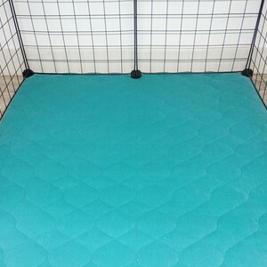 May include: Teal quilted pet bed liner for a large cage. The liner is made of a soft, durable material and is designed to protect the cage floor from scratches and dirt.