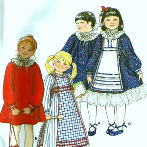 Pode incluir: Um padrão de costura para três vestidos infantis. Os vestidos são em vermelho, azul e branco com um padrão xadrez. O padrão inclui instruções para fazer um vestido com um colarinho com babados, um vestido com um avental xadrez e um vestido com uma borda de renda.