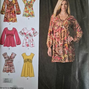 May include: A sewing pattern instruction sheet featuring six variations of a tunic top with different sleeve lengths, necklines, and fabric prints, labeled A through F, alongside a photograph of a model wearing the long-sleeved tunic in a paisley print.