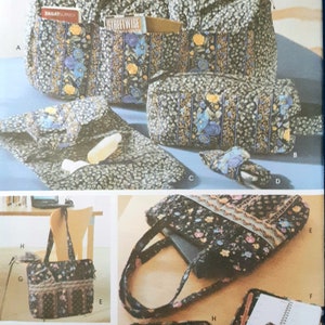 Puede incluir: Un conjunto de bolsos y accesorios de tela acolchada con un estampado floral en negro, azul y amarillo. El conjunto incluye un bolso tote, un neceser, un clutch y un estuche para gafas. Los bolsos tienen bolsillos y asas.