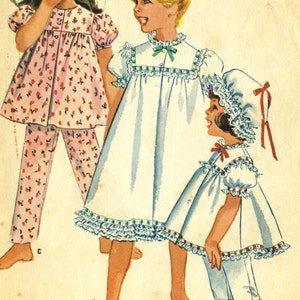 Puede incluir: Ilustración vintage de tres conjuntos de ropa de dormir para niños. Un niño lleva un pijama floral rosa. Otro lleva un vestido blanco con ribete azul. El tercer niño lleva un pijama blanco con un gorro a juego, todo con lazos rojos.