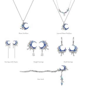 May include: A collection of celestial-themed jewelry featuring crescent moon pendants and earrings. The pieces include a moon necklace, layered moon necklace, earrings with chains, dangle earrings, hook earrings, and a hair stick. The jewelry has a silver finish with blue accents.