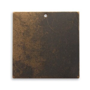 May include: Square, bronze-colored metal plate with a distressed finish. The plate has a small hole at the top for hanging. The surface shows a mottled pattern of dark and light brown tones, suggesting an aged appearance.