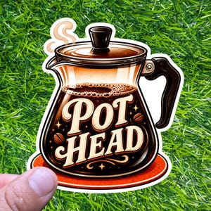 Könnte beinhalten: Ein Aufkleber mit einem Kaffeekannen-Design und den Worten "POT HEAD" im Vintage-Stil. Die Kaffeekanne ist mit dunklem Kaffee gefüllt und hat Dampf, der aufsteigt. Der Aufkleber befindet sich auf einer roten Basis und hat Kaffeebohnen-Akzente.