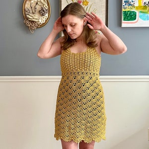 May include: A yellow crochet dress with a scalloped hemline.