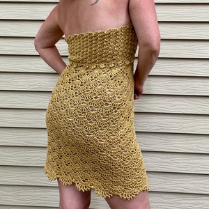 May include: A yellow crochet dress with a strapless neckline and a scalloped hem.