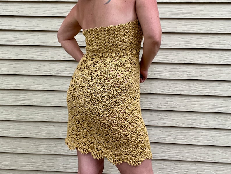 May include: A yellow crochet dress with a strapless neckline and a scalloped hem.