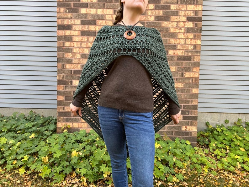 Puede incluir: Un poncho de crochet verde con un patr&oacute;n de diamante. El poncho se lleva sobre un su&eacute;ter marr&oacute;n y unos vaqueros azules.