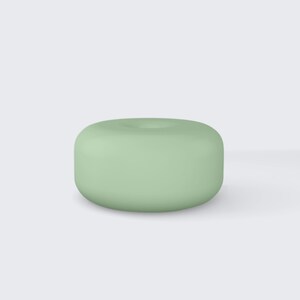 Pode incluir: Um objeto cilíndrico verde claro com um topo arredondado e uma pequena reentrância no centro. O objeto tem um acabamento liso e fosco e um design simples e minimalista. O objeto é de cor sólida.