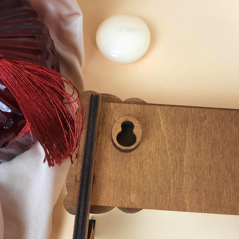 Puede incluir: Primer plano de un estante de madera con un recorte de ojo de cerradura. El estante est&aacute; te&ntilde;ido de un color marr&oacute;n oscuro y tiene un borde decorativo.