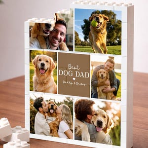 May include: A white building block display featuring six photo panels and a central brown square with the white text "Best DOG DAD" and "Daddy & Bailey" with a heart icon. The display shows various photos of a golden retriever and people.