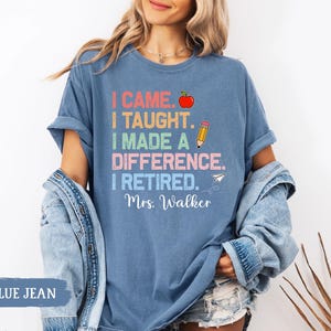 May include: A blue jean t-shirt with the text "I came. I taught. I made a difference. I retired. Mrs. Walker" in rainbow colors with a red apple, pencil, and paper airplane graphic.