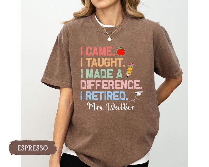 May include: A brown t-shirt with the text "I came. I taught. I made a difference. I retired. Mrs. Walker" in rainbow colors. The text is surrounded by a red apple, a pencil, and a paper airplane.