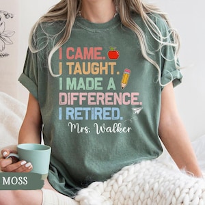 May include: A green t-shirt with a colorful graphic that reads "I came. I taught. I made a difference. I retired. Mrs. Walker". The graphic includes a red apple, a pencil, and a paper airplane.