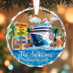 May include: A round, clear glass ornament with a cruise ship design. The ornament features a cruise ship, palm trees, and directional signs pointing to various ports. Text includes "The Jacksons" and "July 14-21, 2025".