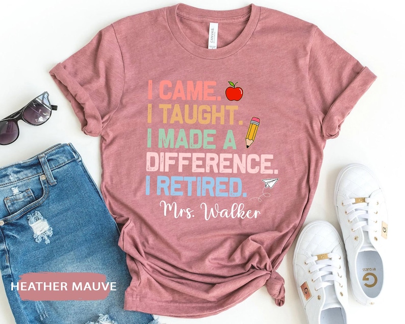 May include: Heather mauve t-shirt with the text "I came. I taught. I made a difference. I retired. Mrs. Walker" in colorful text with an apple and pencil graphic.