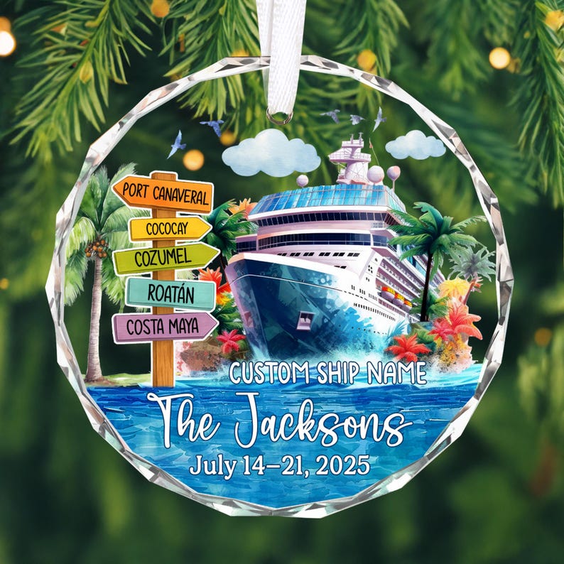 May include: A clear, faceted glass ornament featuring a cruise ship on a blue ocean. The ornament includes a signpost with destination names and the text "The Jacksons" and "July 14-21, 2025". Palm trees and tropical flowers are also visible.
