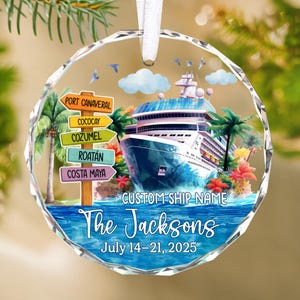 May include: A clear, round Christmas ornament with a cruise ship design. The ornament features a cruise ship, palm trees, and directional signs to various ports. Text includes "The Jacksons" and "July 14-21, 2025". A white ribbon is attached for hanging.